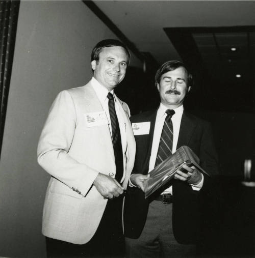 Harry Mitchell presents an award to an unknown man