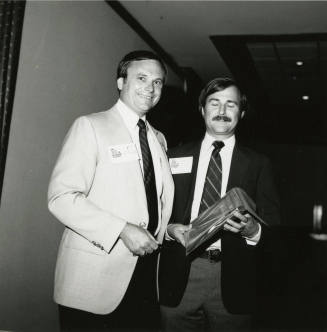 Harry Mitchell presents an award to an unknown man