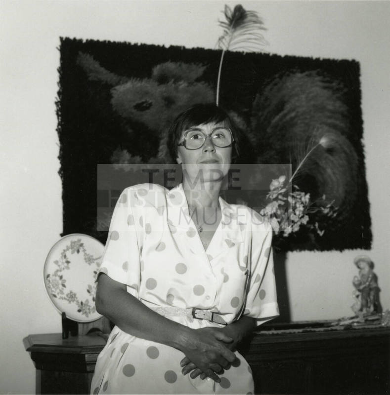 Unknown lady standy in front of a bureau