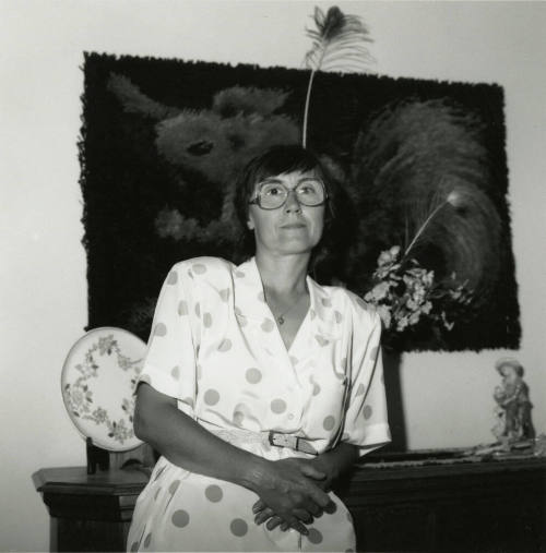 Unknown lady standy in front of a bureau