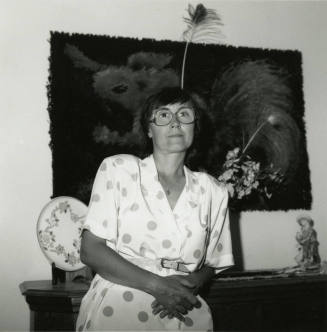 Unknown lady standy in front of a bureau