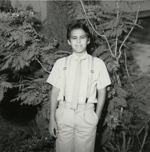 Unidentified Boy Stands In Front of Tree - (1 of 2)