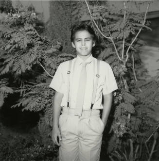 Unidentified Boy Stands In Front of Tree - (1 of 2)