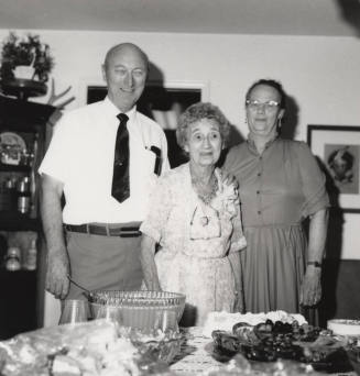 Unidentified Family standing by dinner table