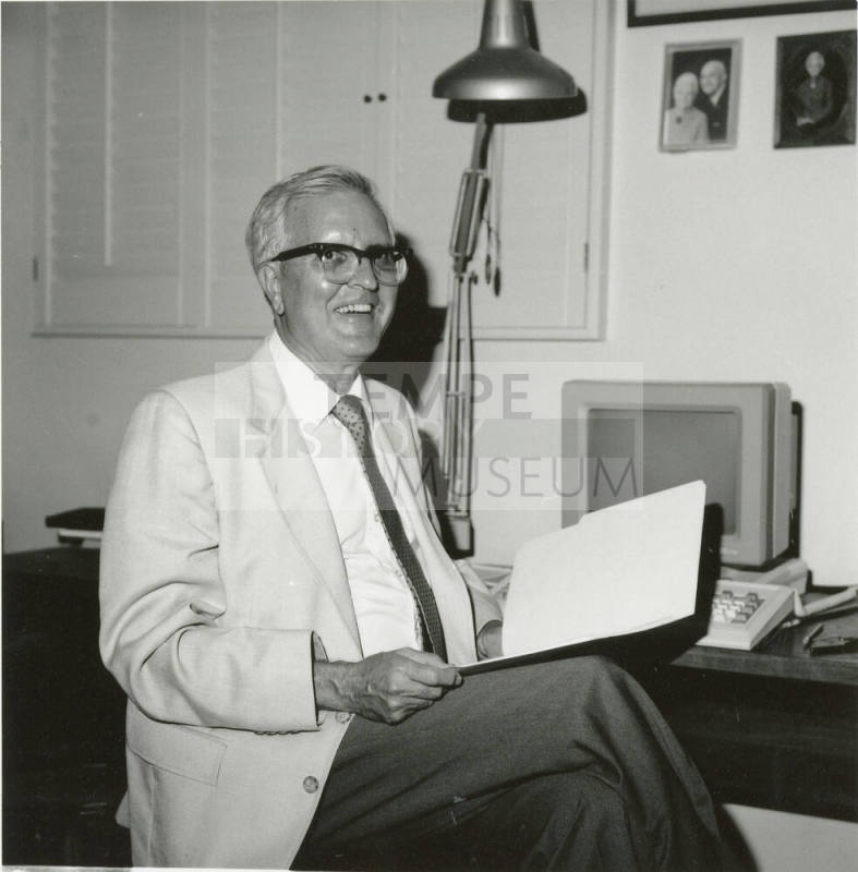 Unidentified man sitting at desk with computer - (1 of 2)