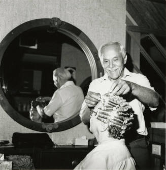 Unidentified man giving woman a permanent