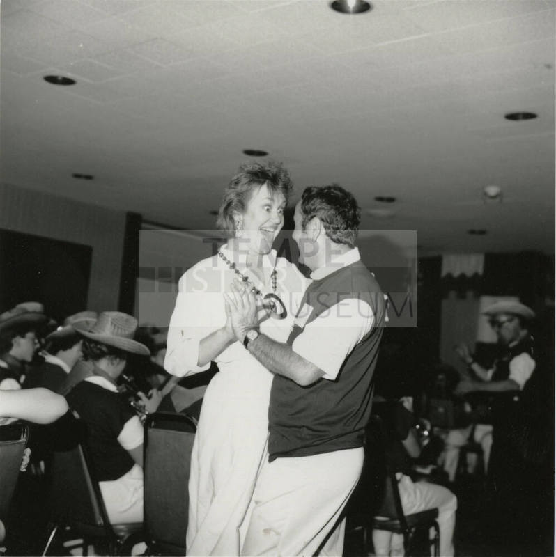 A couple dancing to live music on a dance floor.