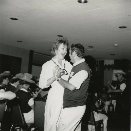 A couple dancing to live music on a dance floor.