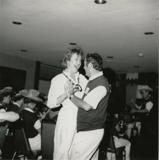 A couple dancing to live music on a dance floor.