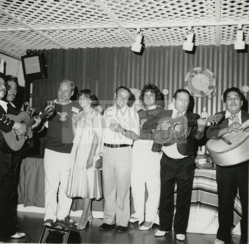 Mexican fiesta - A group of four people listening to a four person Mariachi band play