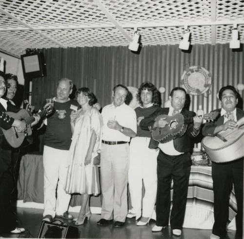 Mexican fiesta - A group of four people listening to a four person Mariachi band play
