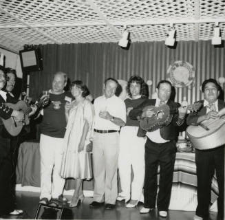 Mexican fiesta - A group of four people listening to a four person Mariachi band play