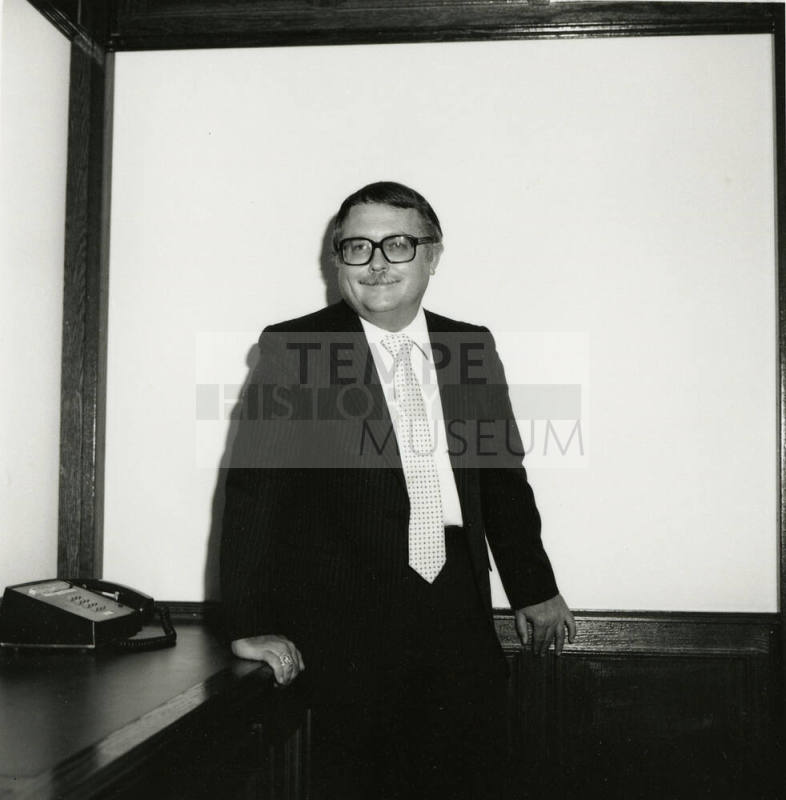 Man dressed in business attire in front of a classroom/meeting white board (2 of 2)