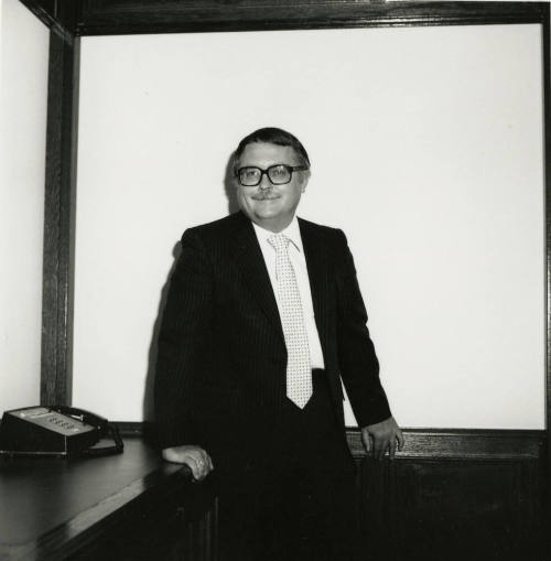 Man dressed in business attire in front of a classroom/meeting white board (2 of 2)