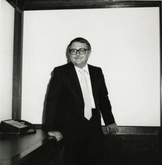 Man dressed in business attire in front of a classroom/meeting white board (2 of 2)