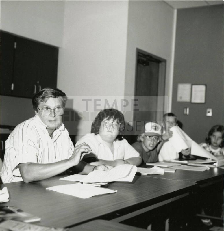 Unidentified group of adults and children sorting through paperwork (2 of 2)