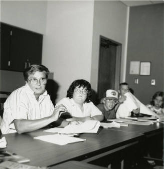 Unidentified group of adults and children sorting through paperwork (2 of 2)