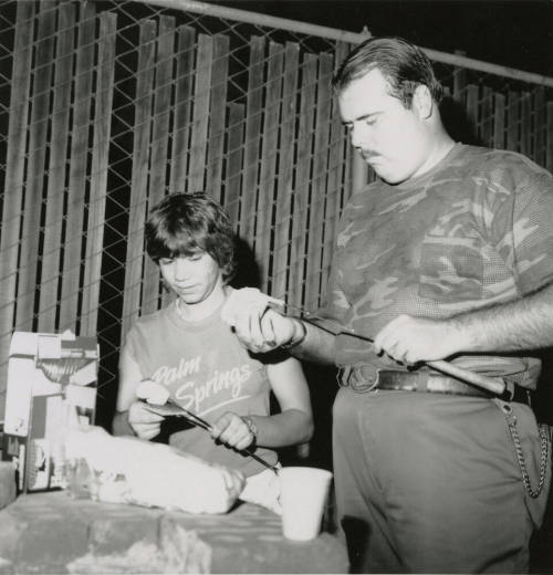 An unknown man and young boy make smores.