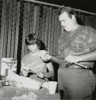 An unknown man and young boy make smores.