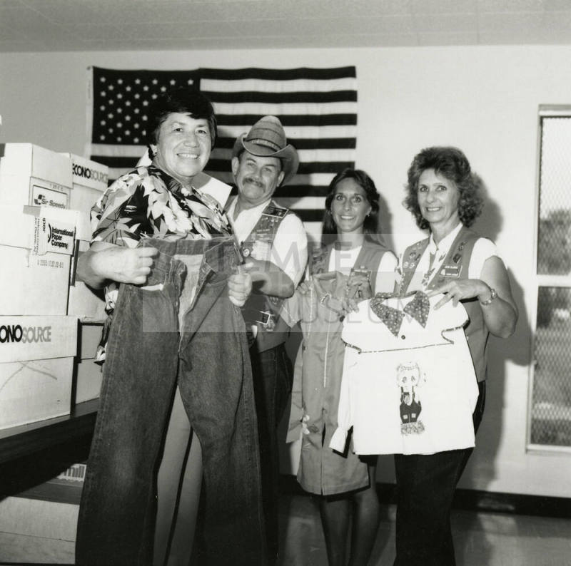 Four unidentified people holding shirts and pants