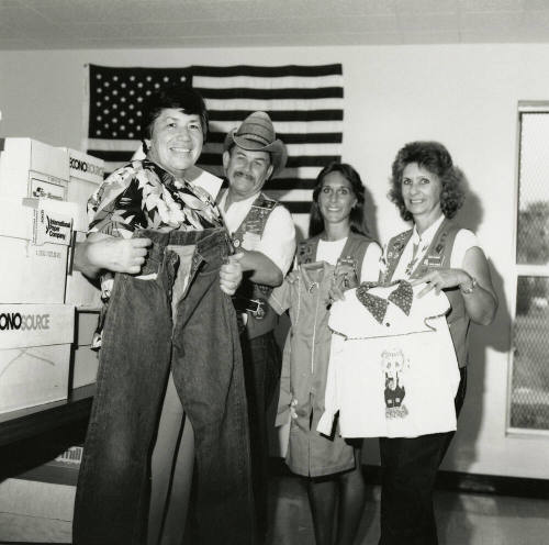Four unidentified people holding shirts and pants