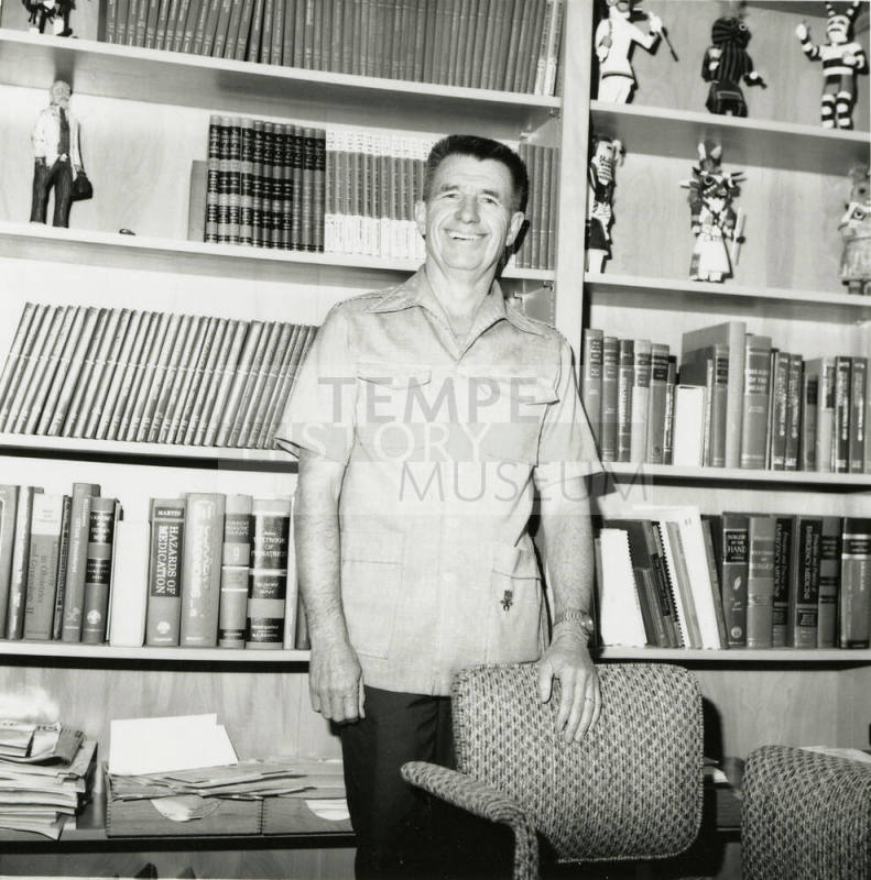 Unidentified man standing in front of a bookshelf