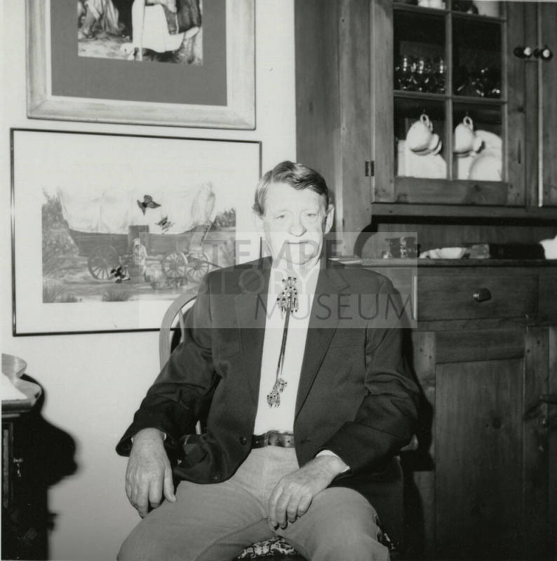 Unidentified seated man wearing bolo tie