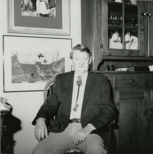 Unidentified seated man wearing bolo tie