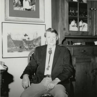 Unidentified seated man wearing bolo tie