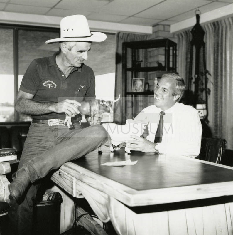 Tex Earnhardt and an unidentifed man at a desk