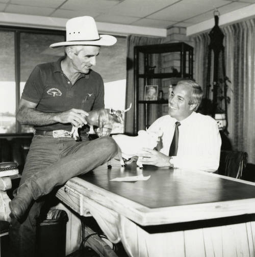 Tex Earnhardt and an unidentifed man at a desk