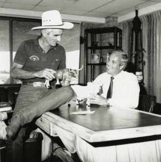 Tex Earnhardt and an unidentifed man at a desk