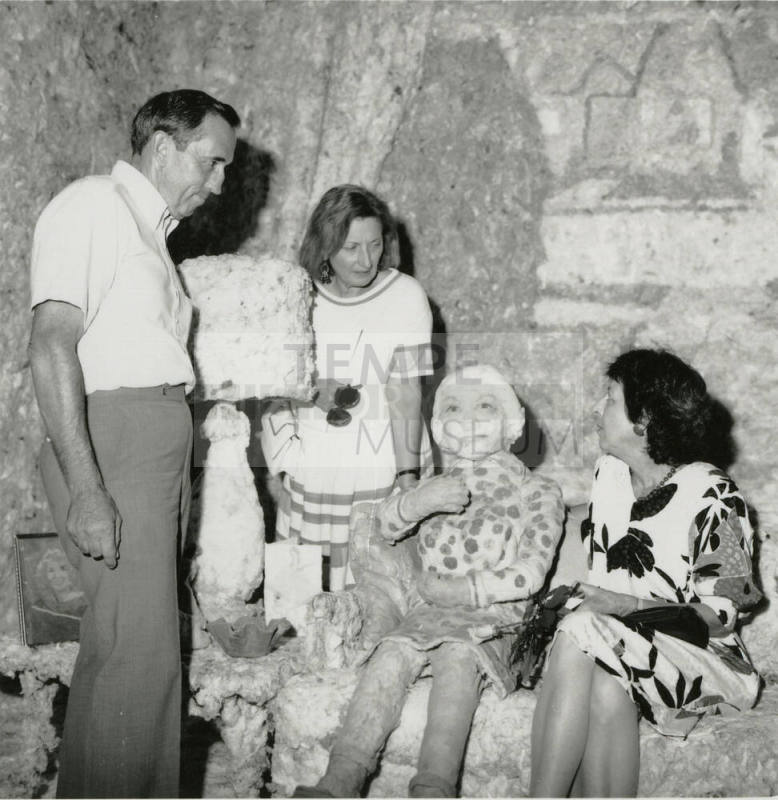 Three unidentified people in a mock room with a mock person