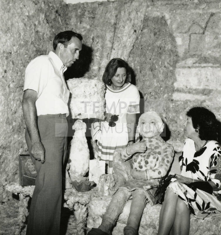 Three unidentified people in a mock room with a mock person