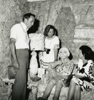 Three unidentified people in a mock room with a mock person