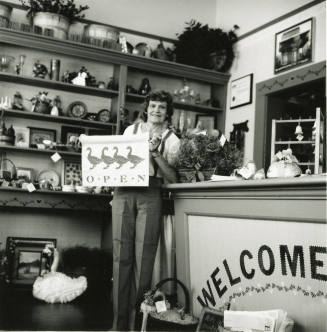 Unidentified lady standing at the counter of a craft shop