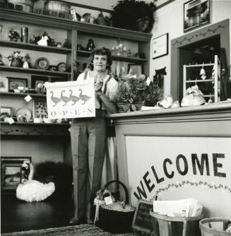 Unidentified lady standing at the counter of a craft shop