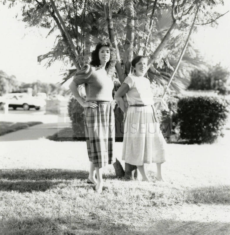 Two unidentified ladies in front of a tree