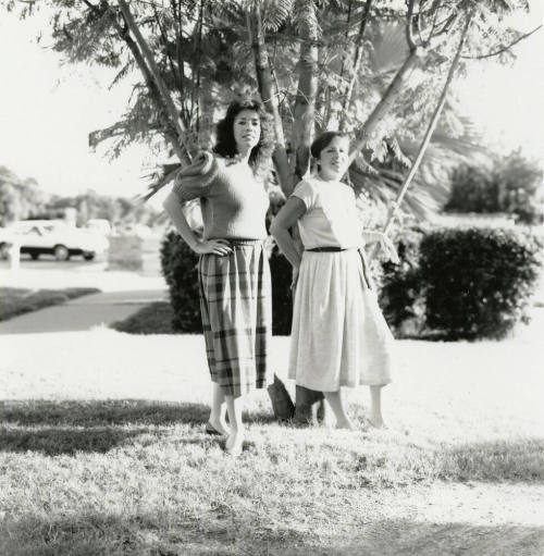 Two unidentified ladies in front of a tree