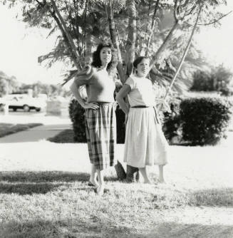 Two unidentified ladies in front of a tree