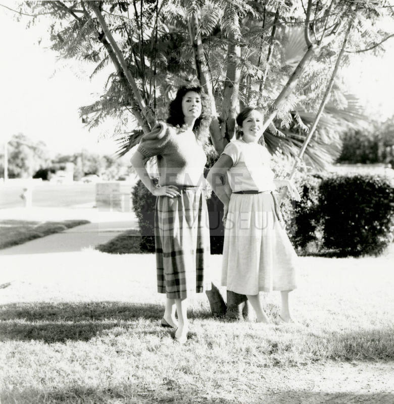 Two unidentified ladies in front of a tree