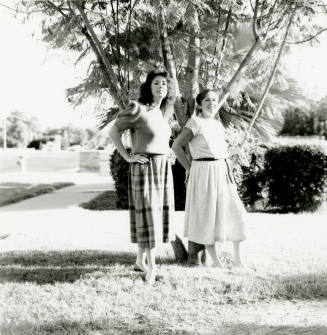 Two unidentified ladies in front of a tree