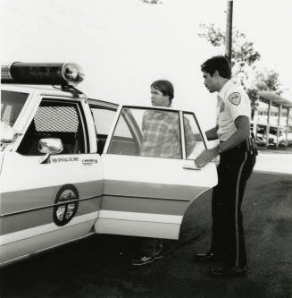 Unidentified Man Put into Police Car by Officer