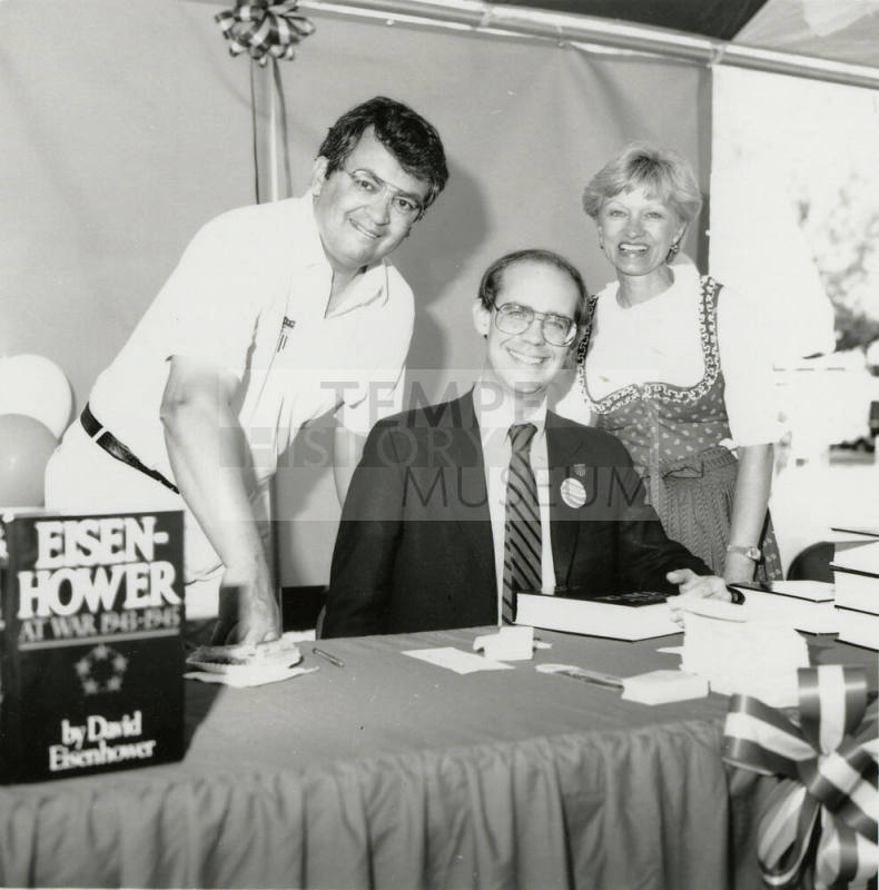 David Eisenhower, Richard (Dick) Neuheisel (standing left), and Jane Neuheisel at a book signing, Sister City Oktoberfest