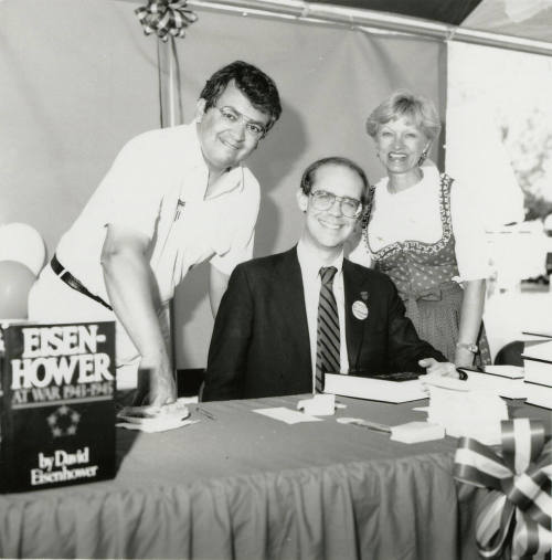 David Eisenhower, Richard (Dick) Neuheisel (standing left), and Jane Neuheisel at a book signing, Sister City Oktoberfest