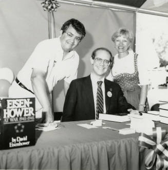 David Eisenhower, Richard (Dick) Neuheisel (standing left), and Jane Neuheisel at a book signing, Sister City Oktoberfest