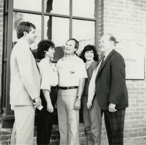 Three unidentified people, Harry Mitchell (center), and Richard Neuheisel (left) at the Hackett House