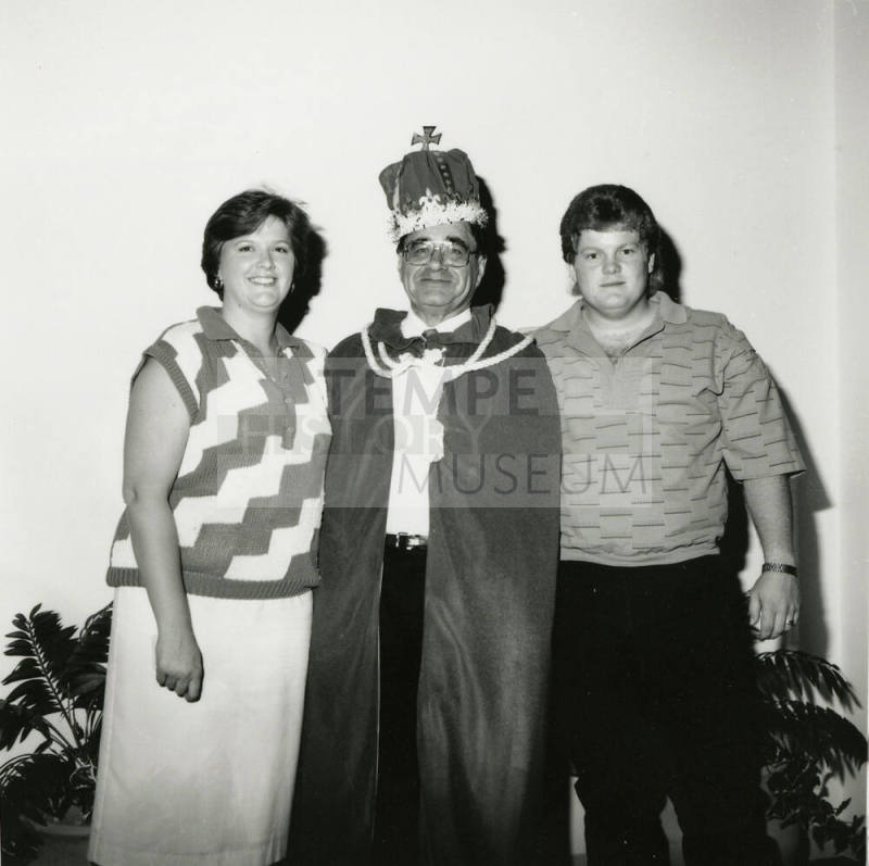Man dressed as king with two other people