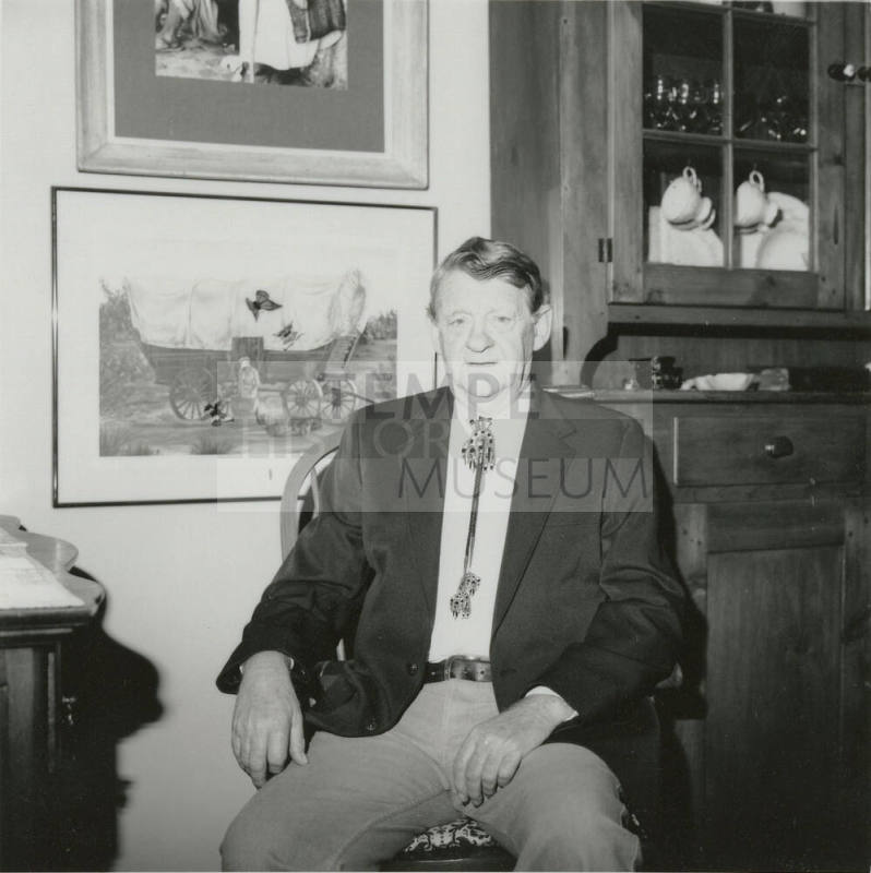 Unidentified seated man wearing bolo tie