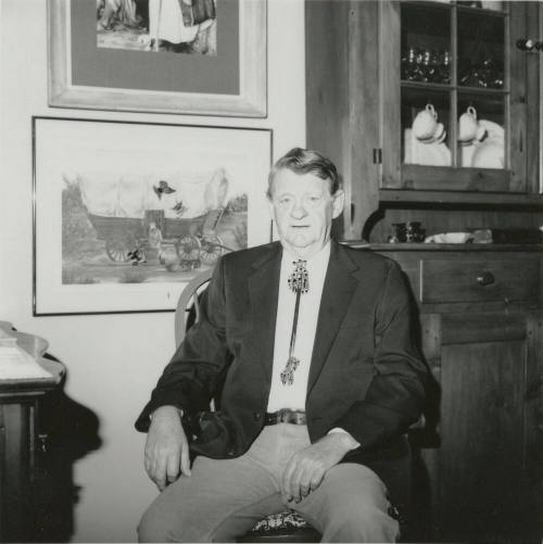 Unidentified seated man wearing bolo tie